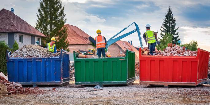 SGM-Mitarbeiter in Schutzausrüstung führt Arbeiten an einem Gebäude mit potenziell gefährlichen Stoffen durch.