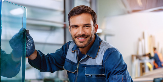 Ein SGM-Glaser arbeitet präzise an einem Glaszuschnitt, um perfekte Passform und höchste Qualität zu gewährleisten.